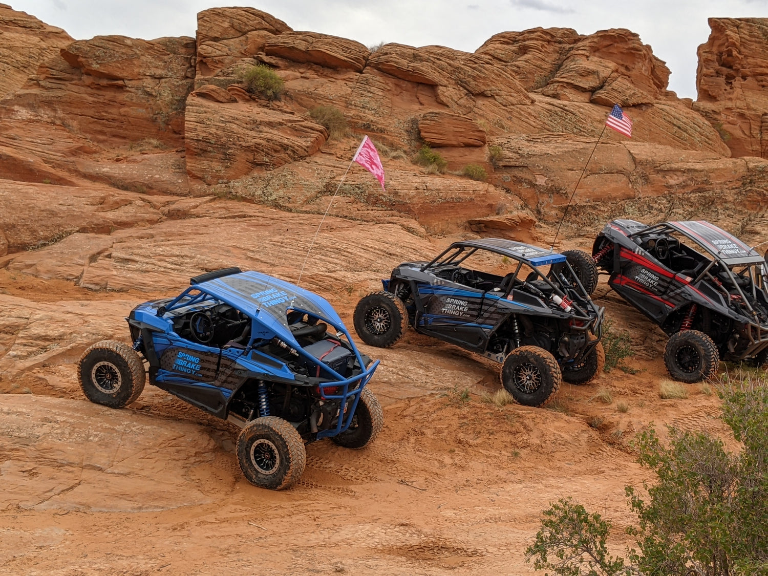three spring brake thingy rzrs parked on an incline on red rocks