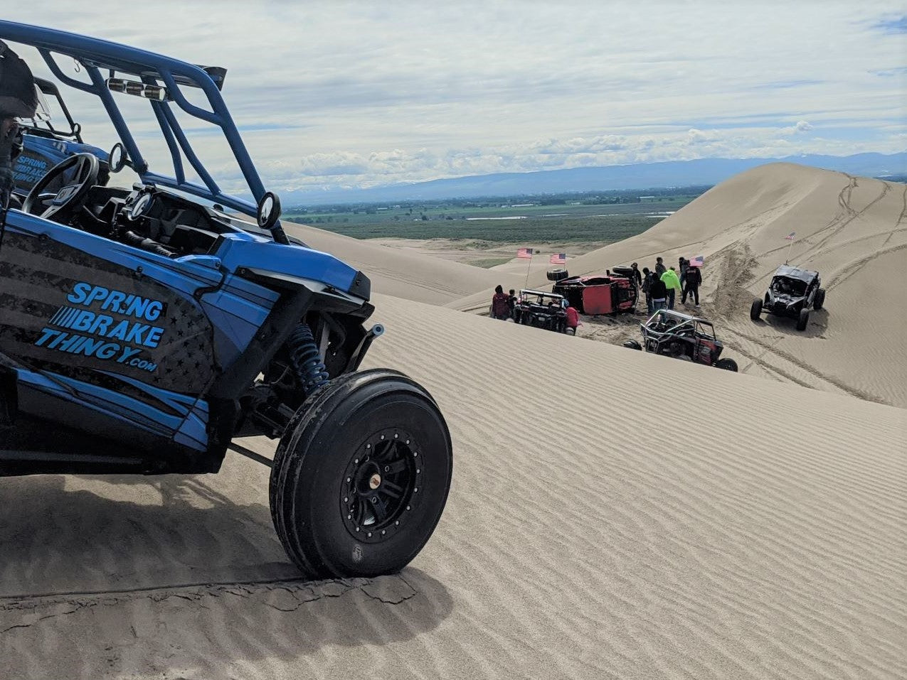 RZR parked on an incline in the sand dunes with spring brake thingy parking brake set because his friend rolled his SxS